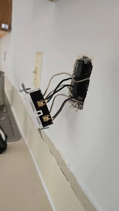 Light switch pulled out from the wall with wires attached during a replacement